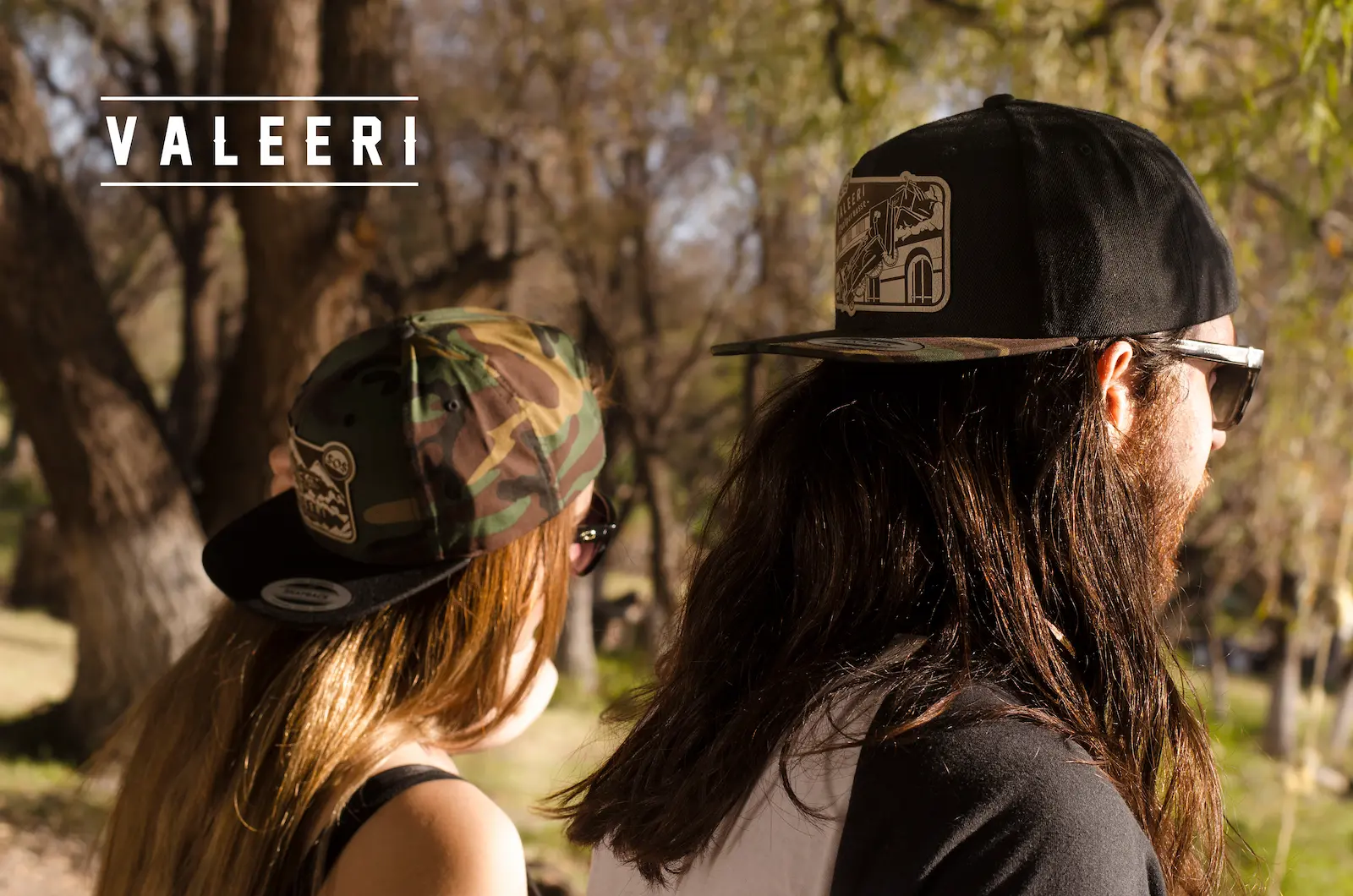 Chica y chico usando gorra Valeeri vistos de espaldas