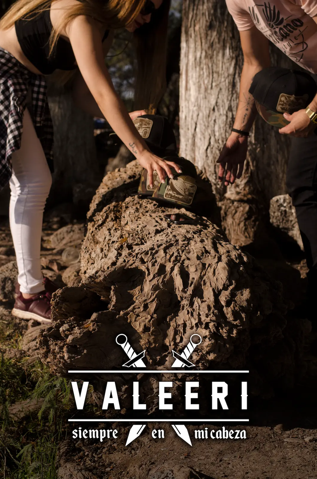 Chica y chico tomando una gorra Valeeri que está sobre una piedra