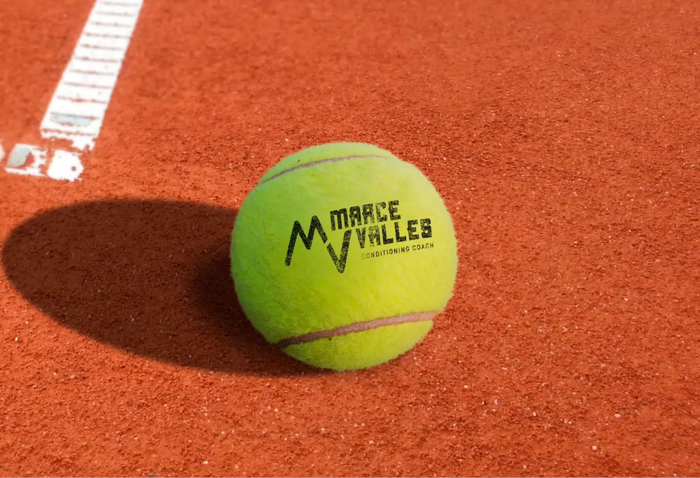 Logotipo de Marce Valles sobre pelota de tennis