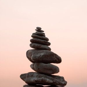 Piedras negras apiladas en fondo rosa claro