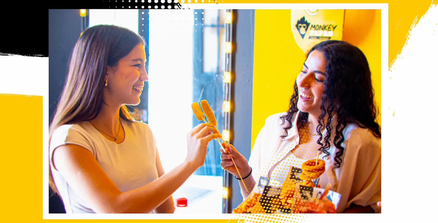 Dos personas compartiendo dedos de queso de Monkey Papas